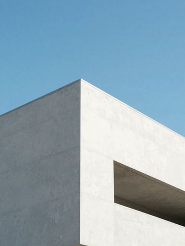 Minimalist architectural concrete structure rising into a clear blue sky, sharp shadows, high-key lighting, 35mm