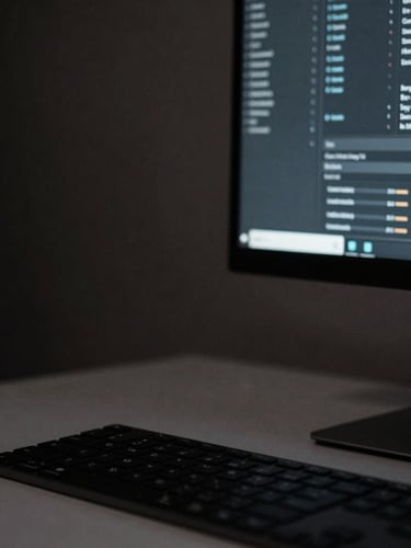 Close-up of a clean minimalist workspace with a high-end monitor showing data charts, moody low-key lighting, deep charcoal tones, sharp focus.