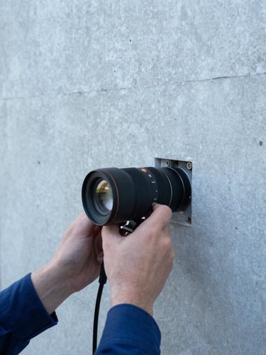 Close-up of a technician using diagnostic equipment on a concrete wall, precise and technical, clean natural daylight, cool blue and concrete gray tones, sharp focus, 35mm lens