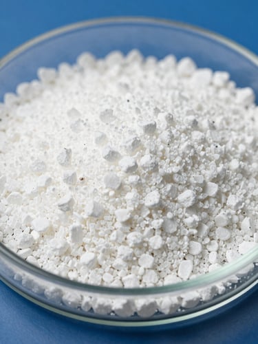 Macro close-up of clean, uniform white Urea 46% fertilizer granules held in a sterile glass laboratory petri dish, bright clinical lighting, sharp focus on chemical texture.