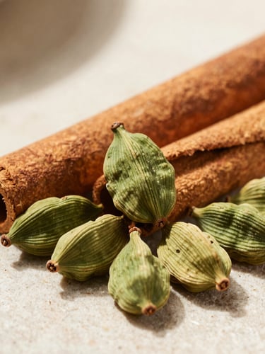 Macro shot of rich cardamom pods and unpolished cinnamon sticks arranged geometrically on a light stone surface, sharp shadows.
