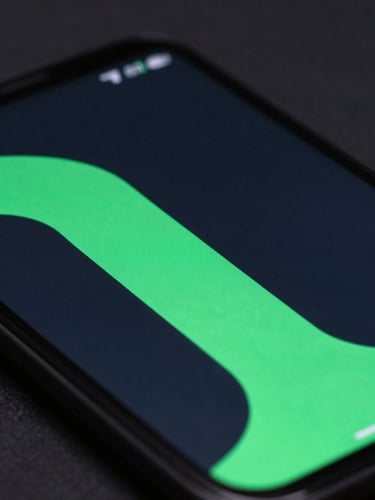 Extreme close-up macro shot of a premium Android device screen displaying a sleek dark-mode interface with electric green accents, moody low-light studio setting