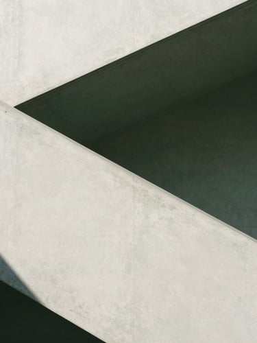 Minimalist modern architectural concrete staircase casting sharp geometric shadows under bright natural light, editorial photography, 35mm lens