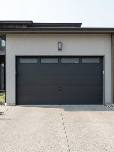 Straight-on architectural shot of a newly installed modern charcoal garage door on a contemporary home, bright natural daylight, crisp focus