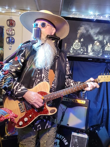 AA Bottom playing Fender electric guitar and harmonica and singing.
