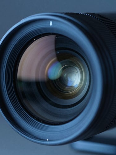 Macro close-up of a high-end thermal surveillance camera lens, cool-toned blue night lighting, sharp technical reflections on the glass surface