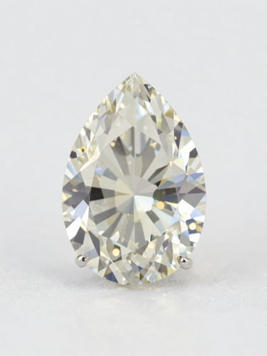 Macro studio photograph of a 104-carat pear-cut diamond render, soft diffused daylight, crisp facets, minimalist white backdrop, 85mm lens