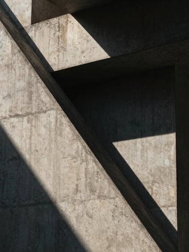 Cinematic close-up of brutalist concrete architecture, sharp diagonal shadows, high-contrast morning sun, muted atmospheric tones