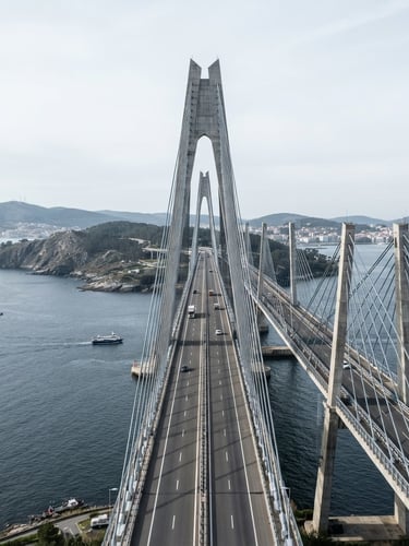 Crisp architectural photography of a modern infrastructure project in Spain, bright cool daylight, desaturated blue and slate tones, sharp orthographic perspective, 35mm