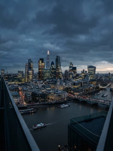 Wide panoramic view of a modern financial district skyline at dusk, architectural framing, deep navy and steel tones, cinematic, high-quality editorial photography