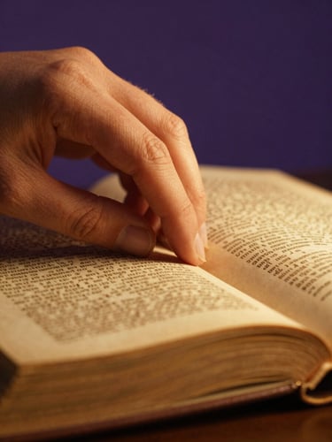 Macro close-up of hands turning the thick, textured page of an ancient academic text, illuminated by a warm golden side-light against a deep twilight violet background.