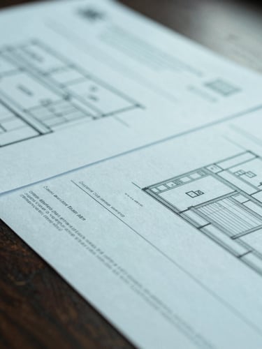 Close-up macro detail of official UK legal documents and architectural plans on a structured dark wood desk, cool soft overcast daylight, desaturated teal tones