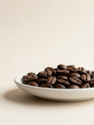 Minimalist close-up of dark roasted coffee beans on a textured off-white ceramic dish, soft natural light, warm earth tones, editorial composition