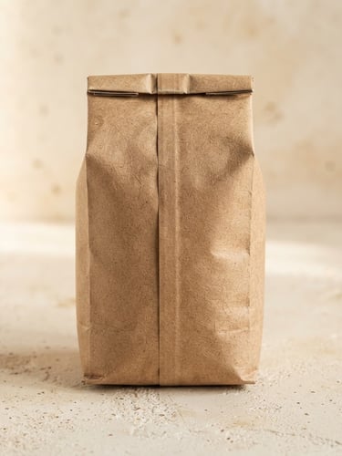 Minimalist studio photography of a 1kg craft paper coffee bag on a textured cream surface, soft diffused daylight, warm earth tones, editorial composition