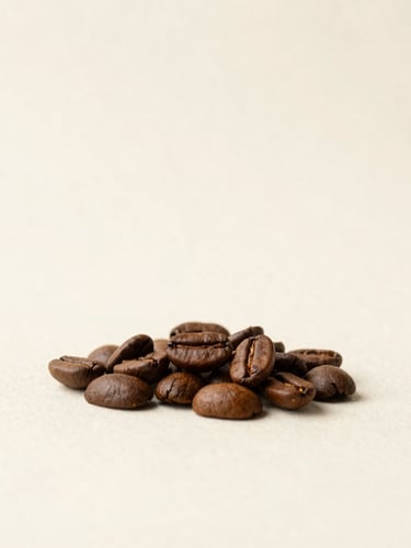 Minimalist studio photography of raw and roasted coffee beans resting on a textured off-white background, soft diffused daylight, warm earth tones, editorial composition, 50mm lens.