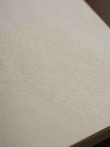 Macro photograph of high-quality fine stationery paper texture, subtle shadows, minimalist and elegant representation of documentation.
