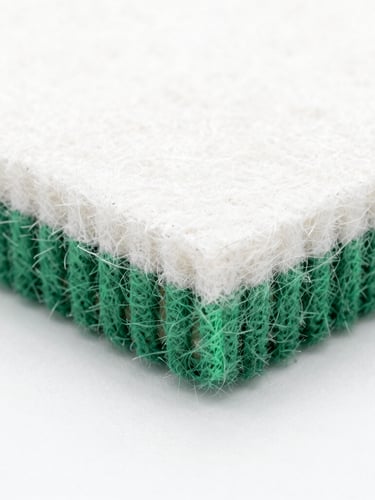 Macro close-up of clean-cut synthetic felt material edge, showing dense needle-punched polyester fibers under bright high-key studio lighting