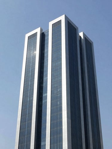 Crisp architectural photography of a modern commercial tower in Doha under bright natural daylight, clean navy and silver tones, sharp focus, professional technical aesthetic.
