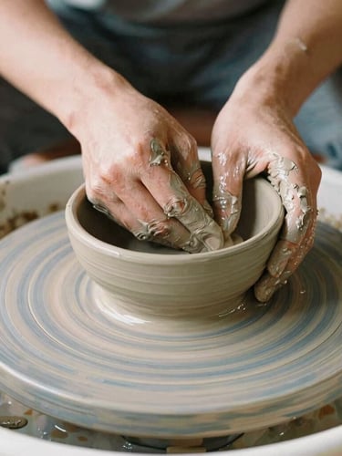 Close-up of potter's hands covered in wet grey clay shaping a rustic bowl on a spinning wooden wheel, warm natural morning light, soft focus, 35mm film.