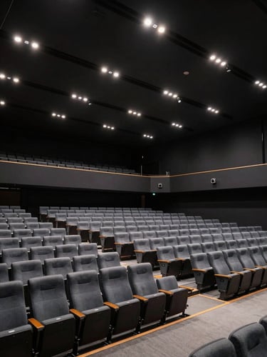 Wide architectural shot of an empty, fully-realized corporate summit auditorium in Zurich, sharp directional spotlights, deep obsidian background.