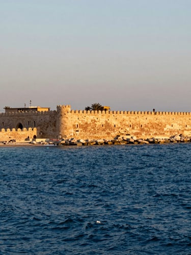 Wide environmental shot of Kayetbay Citadel in Alexandria on the Mediterranean coast, harsh sea spray, dramatic stone battlements against deep blue water, late afternoon light