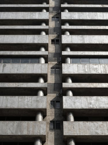 Symmetrical architectural detail of a modern concrete and steel building facade in São Paulo, high contrast daylight, silver and charcoal tones