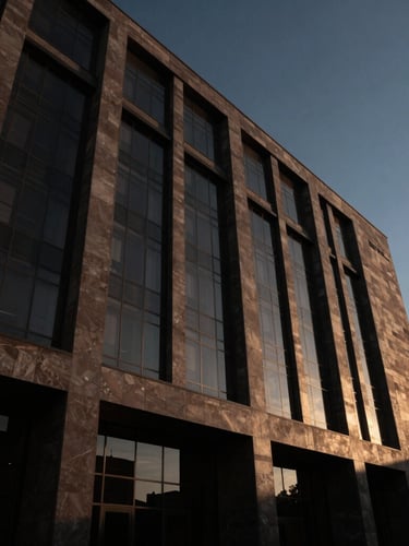 Low-angle dramatic architectural shot of a modern government palace facade in Mexicali, high-contrast shadows, warm sunset light reflecting off dark glass.
