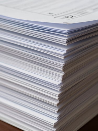 Macro photograph of stacked corporate documents and heavy paper ledgers, focusing on crisp edges and tactile textures in soft daylight.