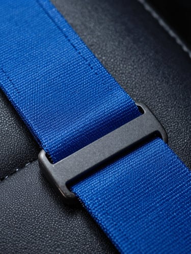 Extreme macro close-up of vibrant electric blue seatbelt fabric being stitched with clinical precision under cool studio lighting, dark leather background