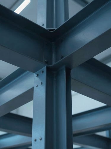 Macro detail of abstract structural steel geometry and clean architectural lines under cool blue industrial lighting, sharp focus, 35mm