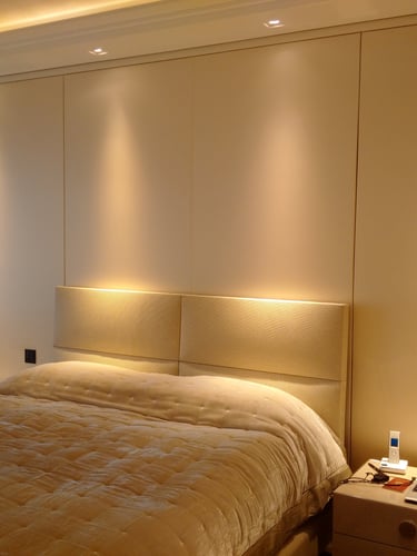 Soft fabric wall finish used behind a bedroom headboard.