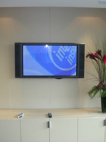 Neutral fabric wall finish around a TV wall with fitted storage unit