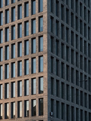 Cinematic architectural photograph of a modern European financial headquarters, sharp concrete lines, dramatic morning window light, 35mm lens