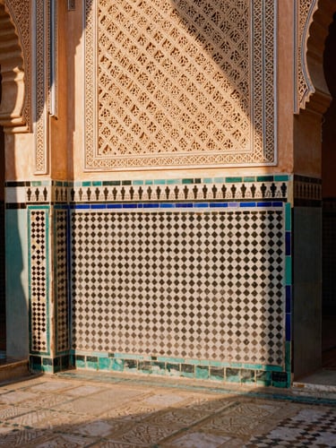 Intricate Islamic mosaic tiles on a courtyard wall in Marrakech, warm morning sunlight casting soft shadows across the geometric patterns, 35mm film.