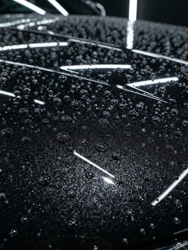 Extreme macro close-up of a deep metallic black car hood, razor-sharp LED light reflections showing zero swirl marks, water droplets perfectly beaded on ceramic coating, 35mm automotive studio photography.