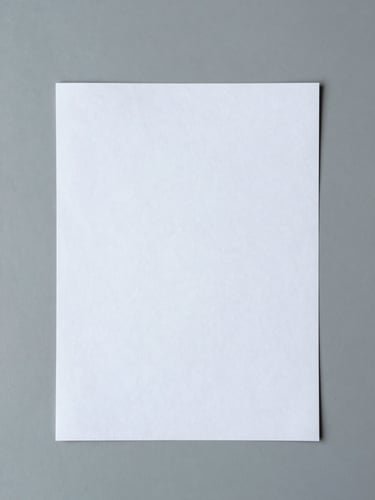 Top-down flat lay of clean editorial proofs on a cool gray desk, soft diffused daylight, minimalist workspace