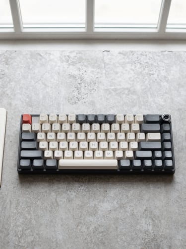 Overhead minimalist flat-lay of a mechanical keyboard, a clean notebook, and a black fountain pen on a neutral grey concrete desk, bright natural window light, sharp focus, 35mm lens