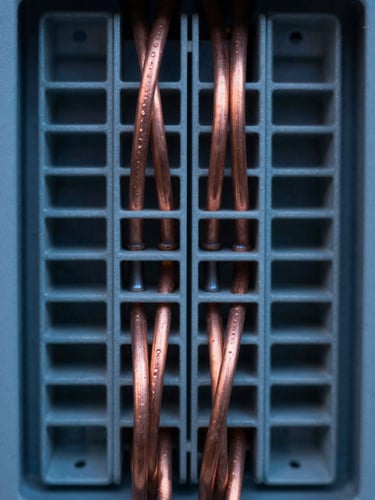 Extreme macro close-up of perfectly dressed, symmetrical copper cabling inside an industrial-grade distribution board, cool twilight lighting, sharp focus, 35mm