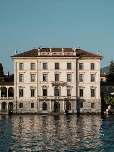 Elegant historic villa facade on Lake Maggiore, soft afternoon sunlight reflecting off the calm water, architectural symmetry, editorial photography style.
