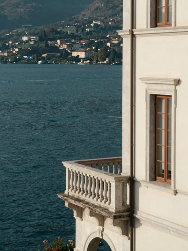 Elegant editorial photography of a historic villa balcony overlooking Lake Maggiore, soft morning light, deep teal water, medium format