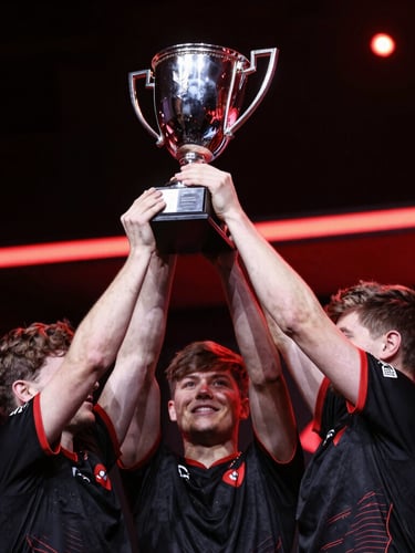 Dynamic low-angle shot of professional esports athletes lifting a silver trophy under dramatic crimson red rim lights, high-contrast studio lighting, 35mm