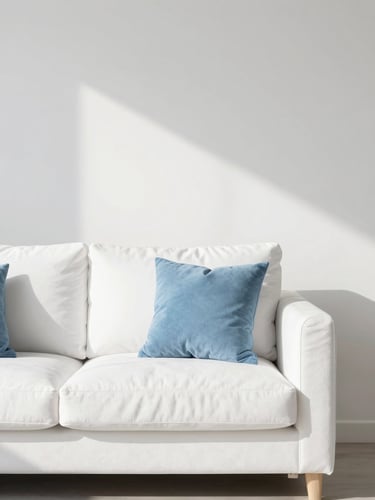 Bright sun-drenched minimalist living room, clean white sofa, soft blue cushions, sharp focus, editorial photography