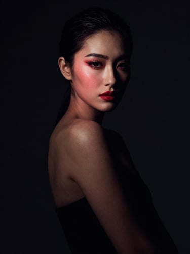 A sophisticated editorial portrait celebrating identity, elegant pose, dramatic high-contrast lighting with a subtle crimson gel accent, dark background
