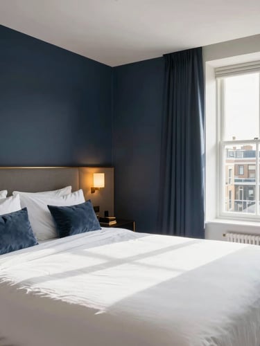 Bright wide-angle interior photography of a pristine London Airbnb bedroom, crisp white linens on a perfectly made bed, warm sunlight streaming through a window, deep navy accents