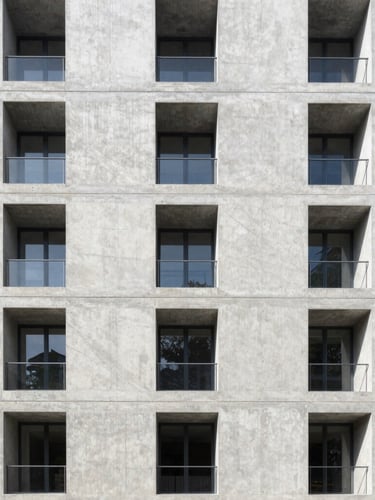Symmetrical architectural photography of a modern concrete building facade, sharp lines, bright natural daylight, technical blueprint feel.