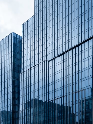 Crisp architectural photography of a modern high-rise glass facade reflecting cool daylight, sharp lines, clean corporate minimalism, royal blue ambient tint