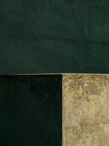 Minimalist architectural photography, sharp direct sunlight with deep shadows on a concrete wall, dark forest green tones, 35mm