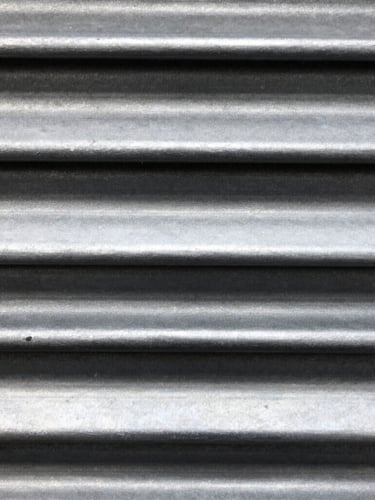 Macro shot of steel roller shutter mechanism, high-contrast metallic highlights, industrial editorial photography, sharp focus, 35mm
