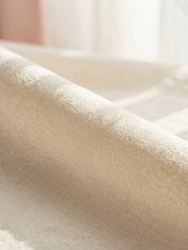 Macro close-up of textured cream linen fabric, soft natural window light casting gentle shadows, showing fine weave and craftsmanship, warm-minimalist aesthetic, 35mm