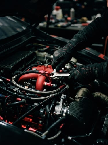 Close-up shot of a mechanic's hands in black racing gloves, adjusting a high-performance engine bay, dramatic moody garage lighting with strong directional key light, deep shadows, 35mm.
